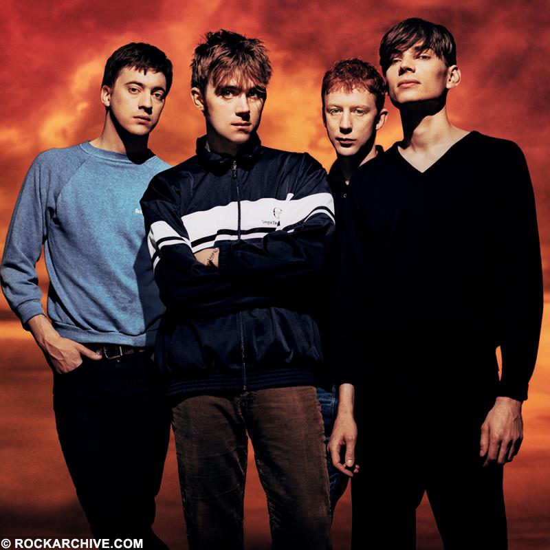 90’LARIN ALTERNATİF MÜZİĞİ: ROCK’IN YÖNÜNÜ DEĞİŞTİREN ŞARKILAR 4 blur bu003kw stood against an orange landscape